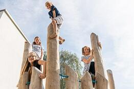 Kinder spielen im Spielplatz aus Robinienholz